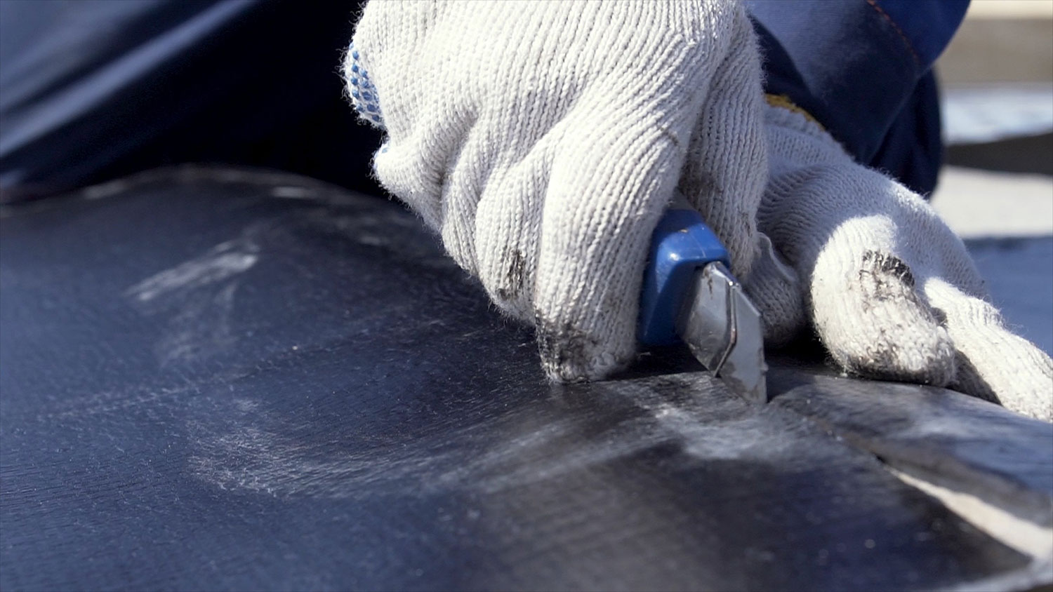 roofer using a utility knife